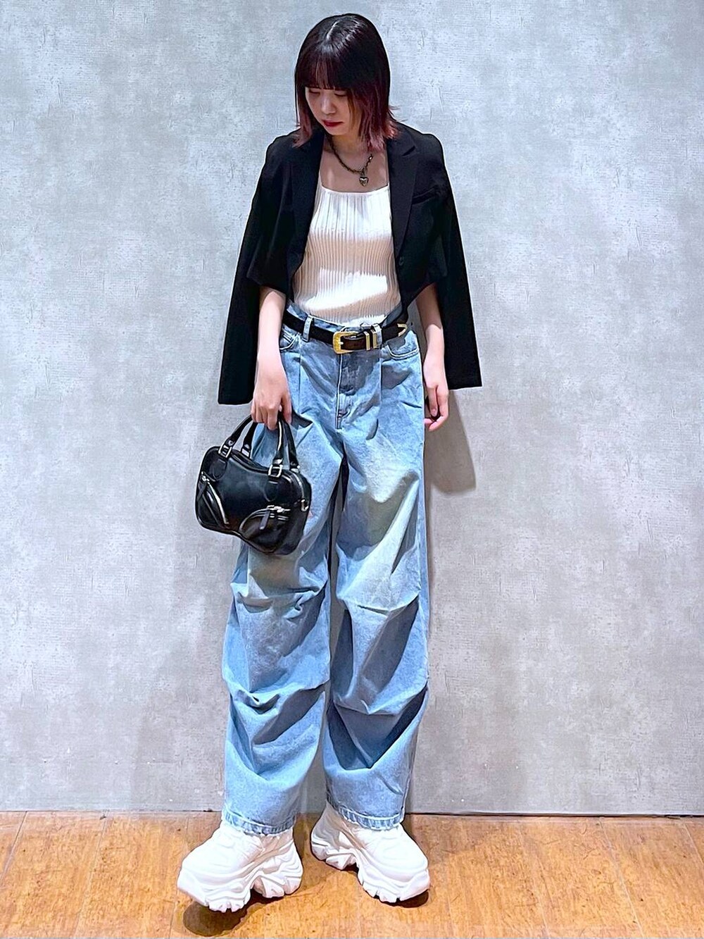 ホワイト系のタンクトップ、ホワイト系のスニーカー、ブラック系のボストンバッグを着用したレディースの春コーディネートの2枚目の写真