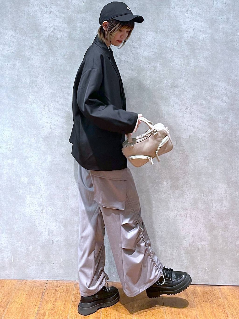 ブラック系のテーラードジャケット、ホワイト系のTシャツ/カットソー、ブラック系のブーツを着用したレディースの冬コーディネートの4枚目の写真