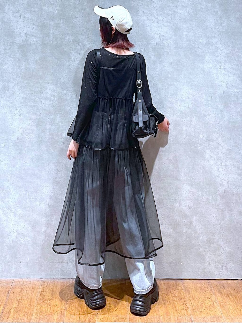 ブラック系のショルダーバッグ、ブラック系のスニーカー、ブルー系のデニムパンツを着用したレディースの春コーディネートの6枚目の写真