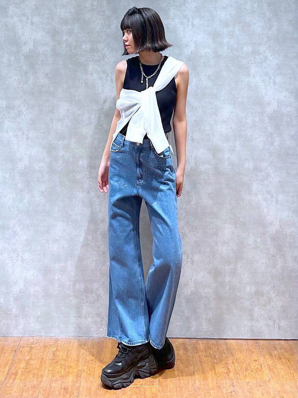 ブラック系のスニーカー、ブラック系のタンクトップ、ブルー系のデニムパンツを着用したレディースの夏コーディネートの8枚目の写真