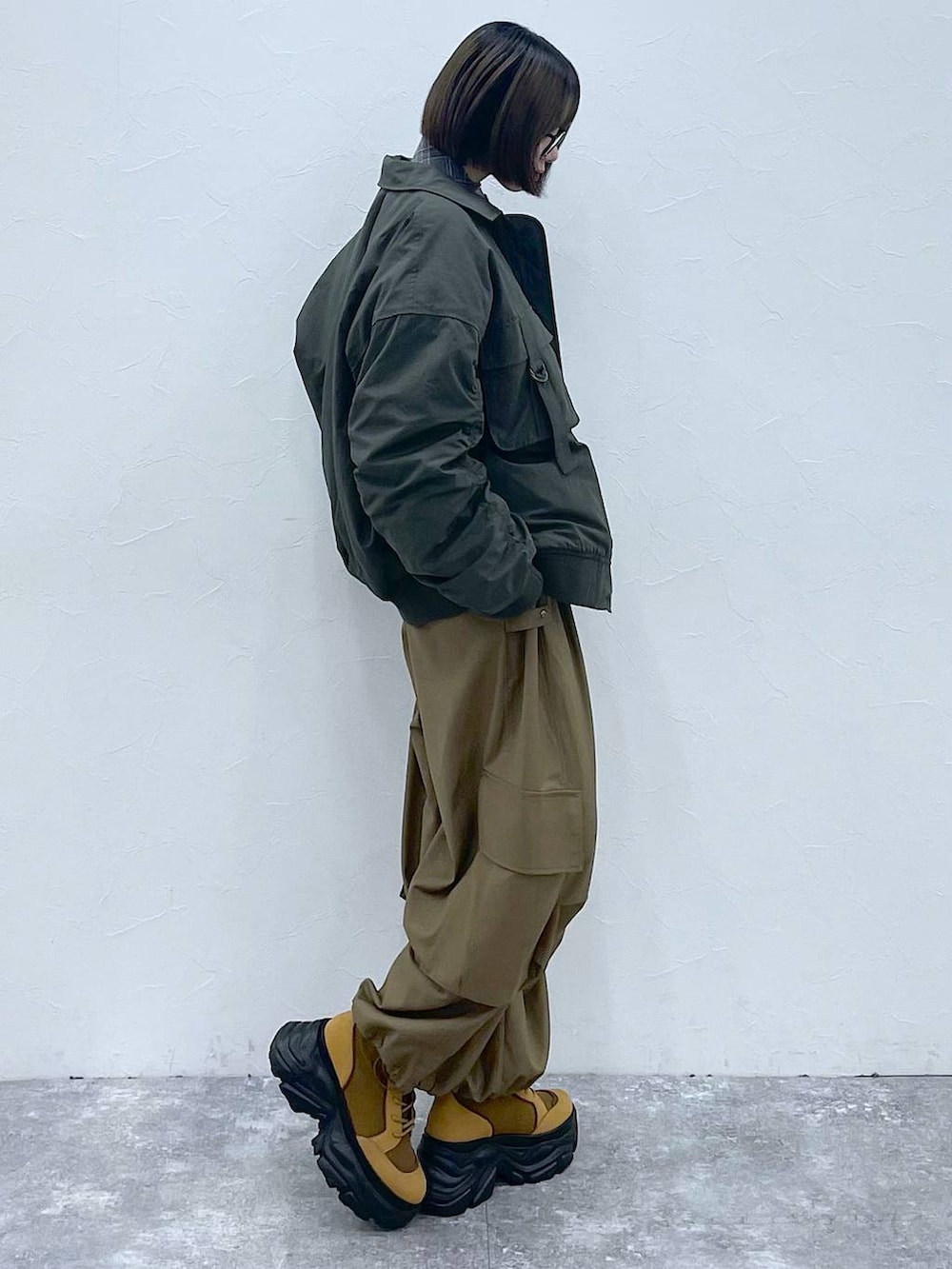 グレー系のネクタイ、ブラウン系のブーツ、グリーン系のブルゾンを着用したレディースの秋コーディネートの7枚目の写真