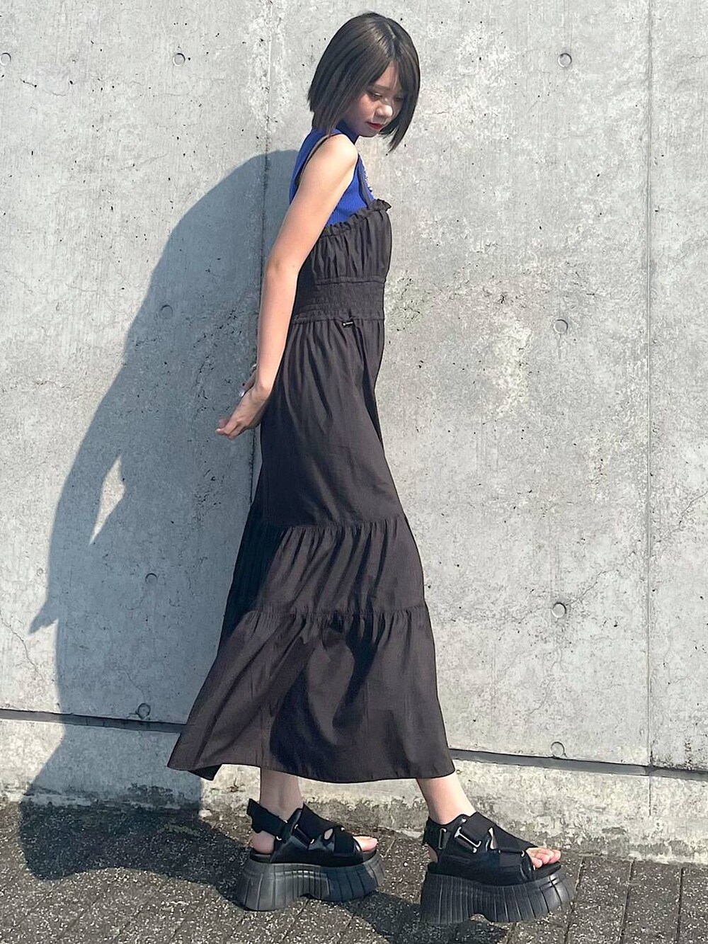 ブラック系のスニーカー、ブラック系のワンピース、シルバー系のネックレスを着用したレディースの夏コーディネートの2枚目の写真
