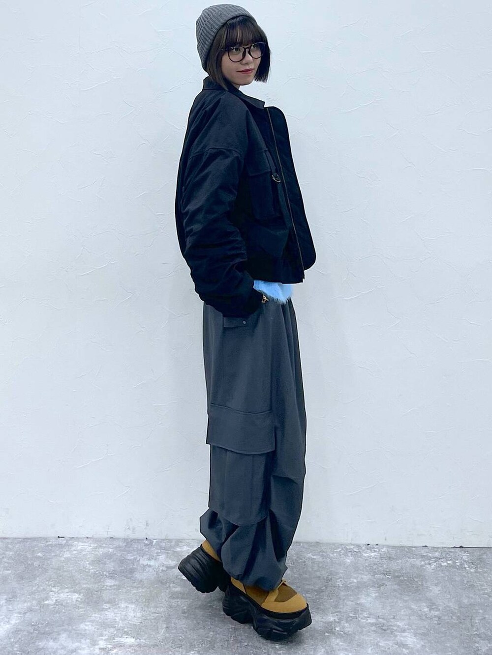 ブラウン系のブーツ、ブラック系のブルゾン、グレー系のカーゴパンツを着用したレディースの秋コーディネートの7枚目の写真