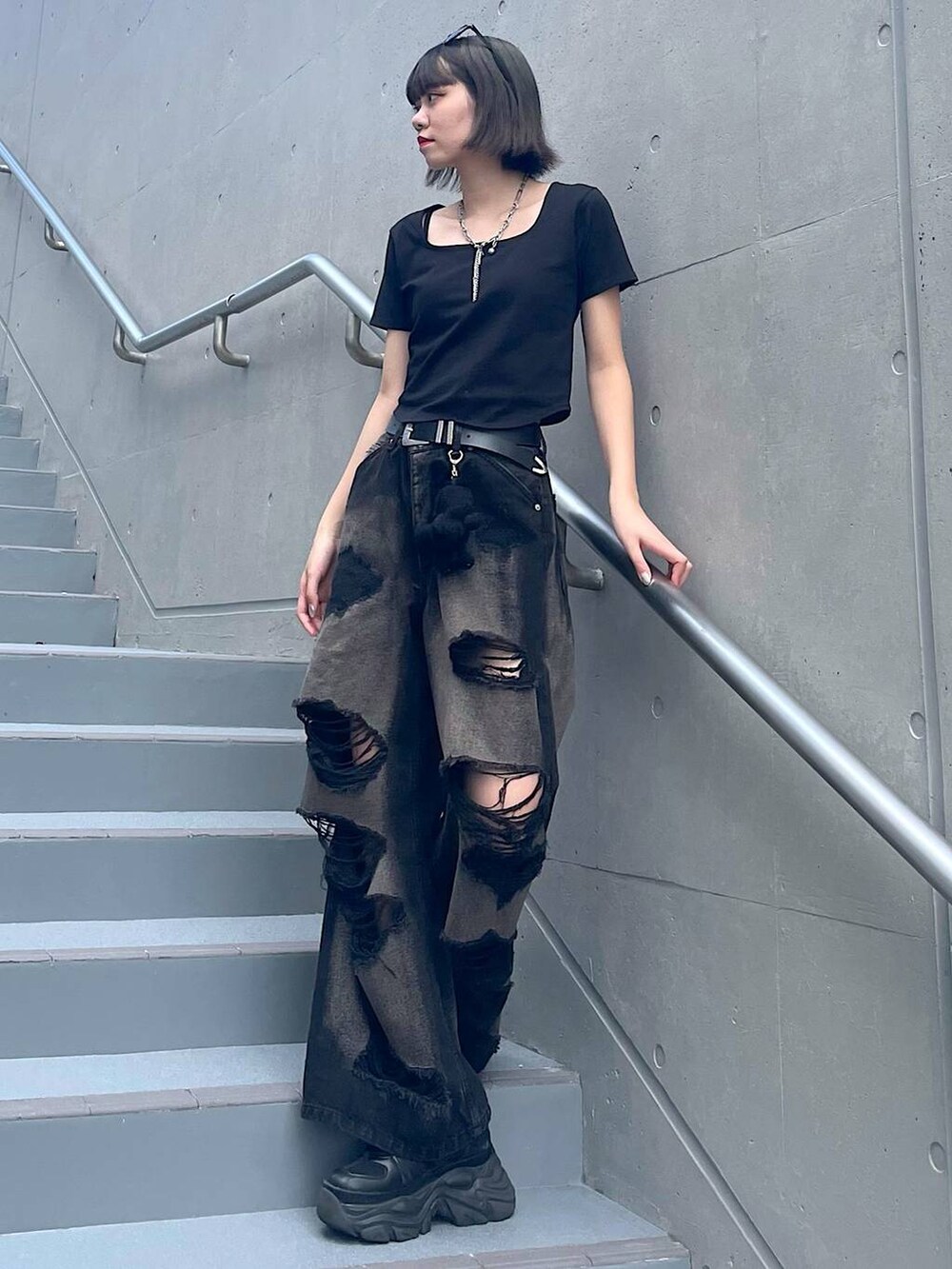 ブラック系のスニーカー、ブラック系のデニムパンツ、ブラック系のTシャツ/カットソーを着用したレディースの夏コーディネートの2枚目の写真