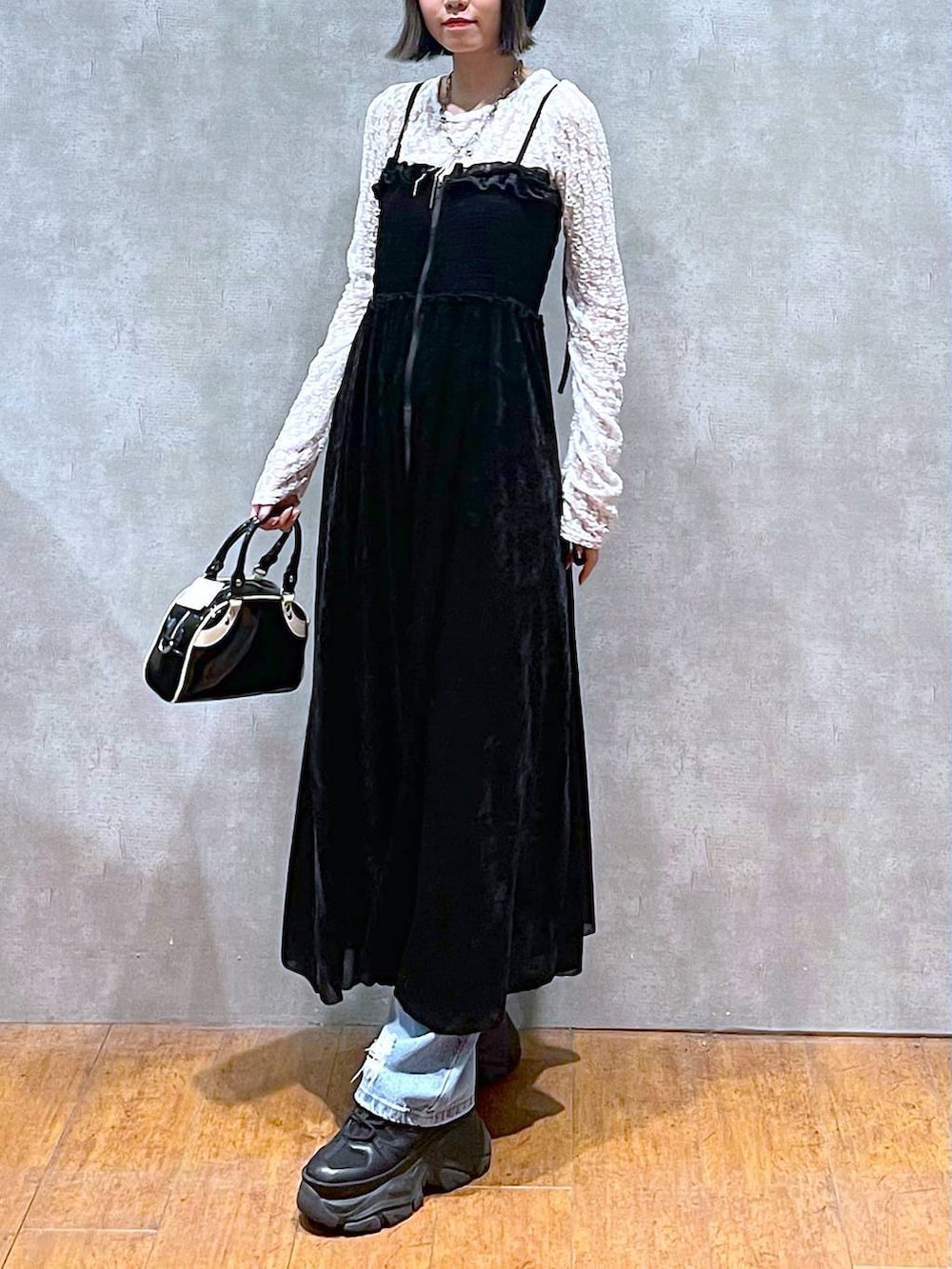 ブラック系のスニーカー、ブラック系のショルダーバッグ、ブルー系のデニムパンツを着用したレディースの夏コーディネートの3枚目の写真