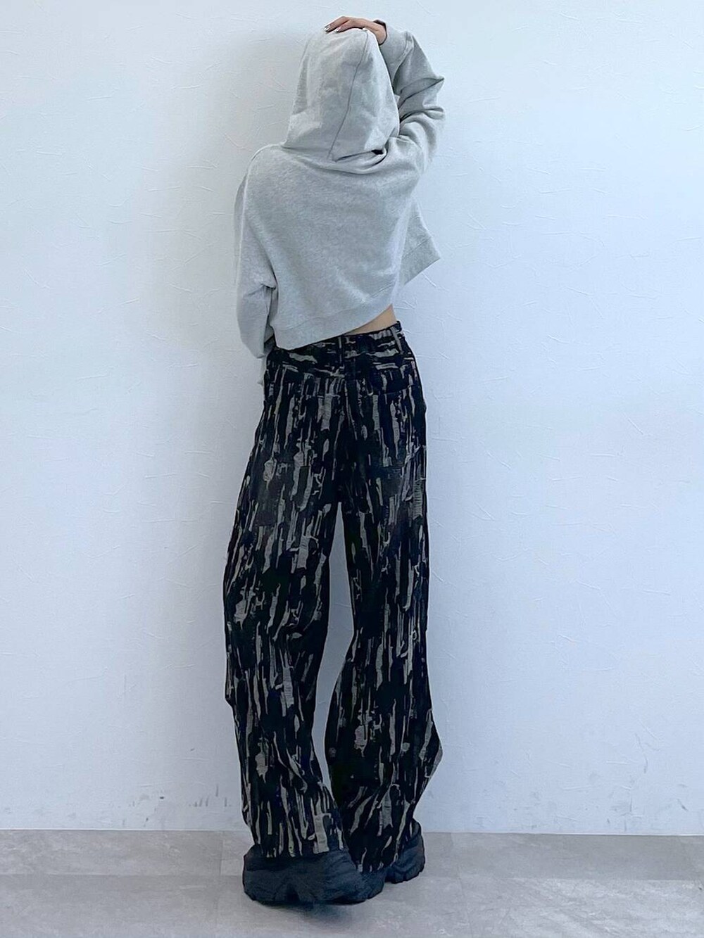 グレー系のパーカー、ホワイト系のキャミソール、ブラック系のスニーカーを着用したレディースの秋コーディネートの6枚目の写真