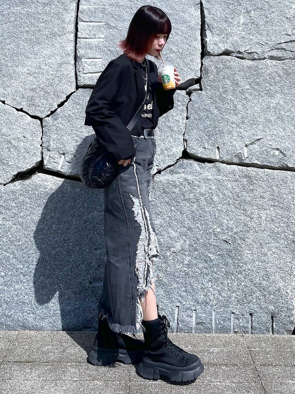 ブラック系のショルダーバッグ、ブラック系のブーツ、ブラック系のデニムスカートを着用したレディースの春コーディネートの5枚目の写真