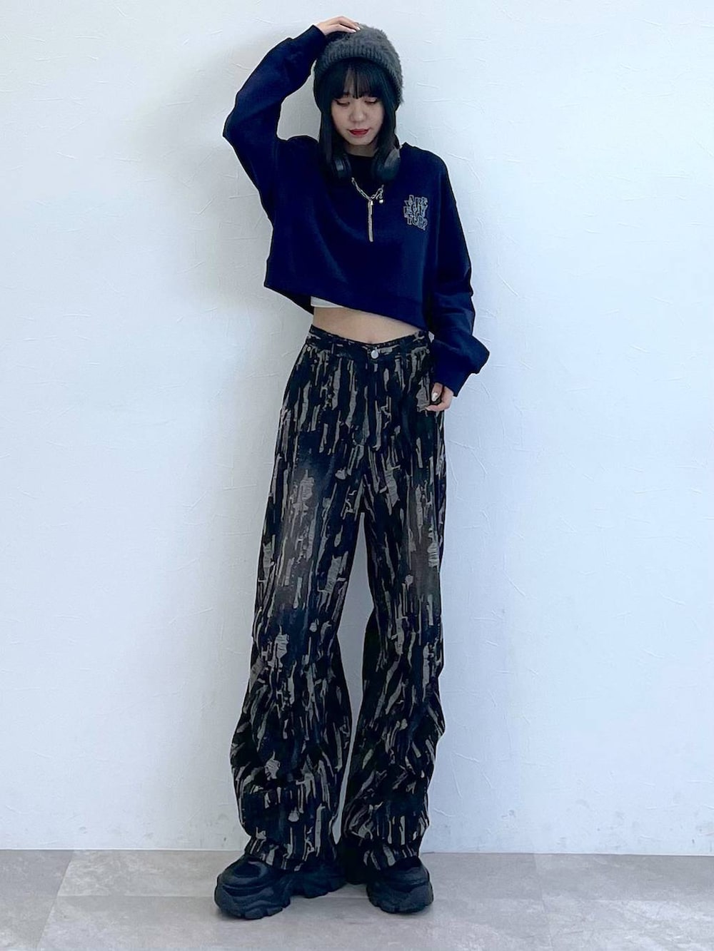 ブラック系のスニーカー、ブラック系のデニムパンツ、ホワイト系のキャミソールを着用したレディースの秋コーディネートの8枚目の写真