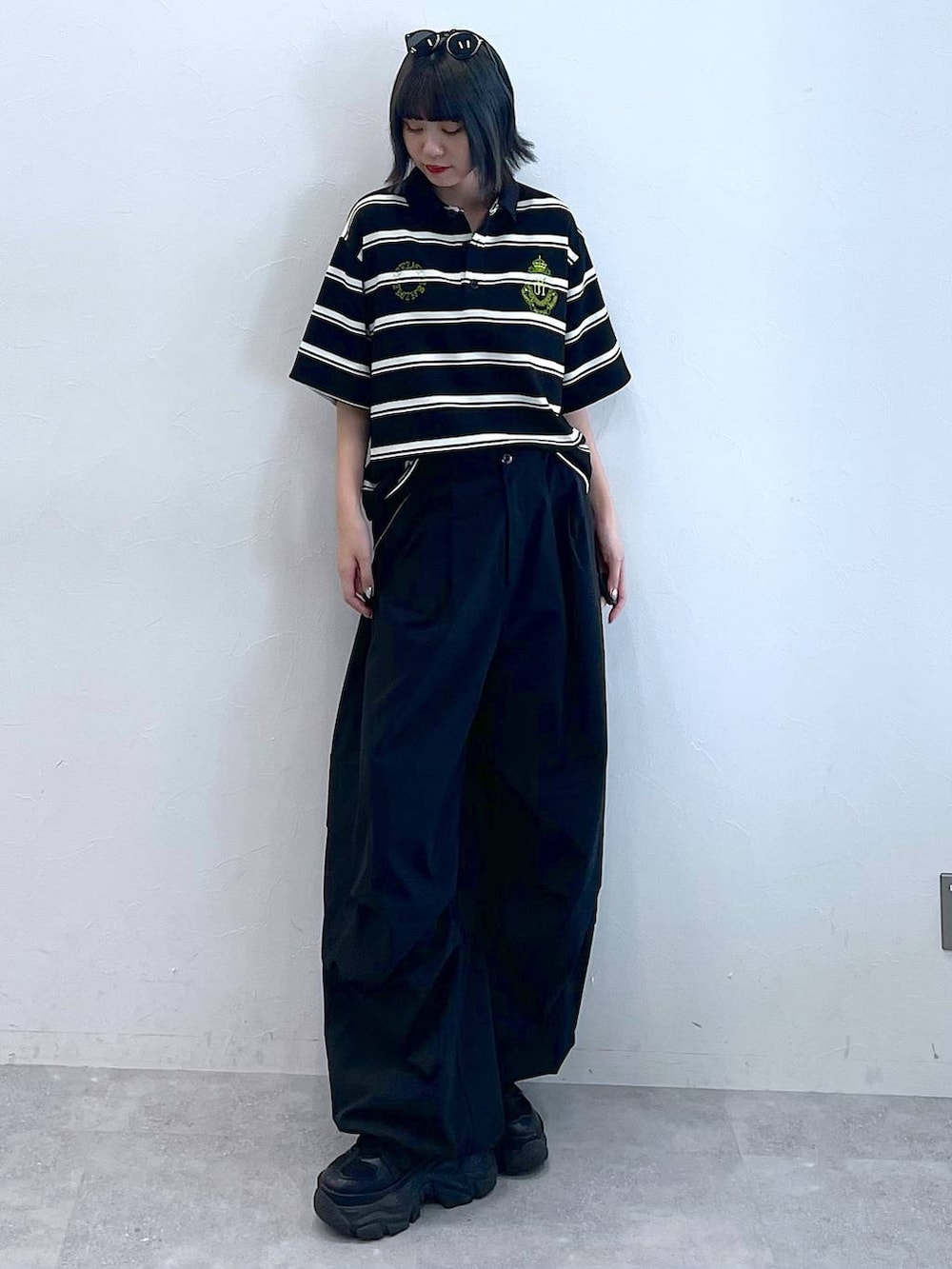 ブラック系のスニーカー、ブラック系のカーゴパンツ、ブラック系のTシャツ/カットソーを着用したレディースの夏コーディネートの2枚目の写真