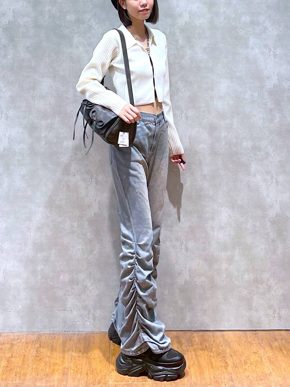 ブラック系のスニーカー、ブラック系のショルダーバッグ、ブラック系のキャミソールを着用したレディースの秋コーディネートの3枚目の写真