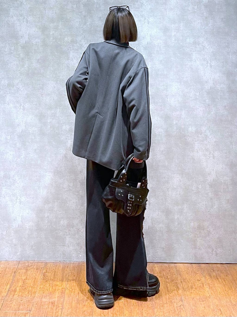 ブラック系のスニーカー、レッド系のニット/セーター、ブラック系のハンドバッグを着用したレディースの秋コーディネートの7枚目の写真