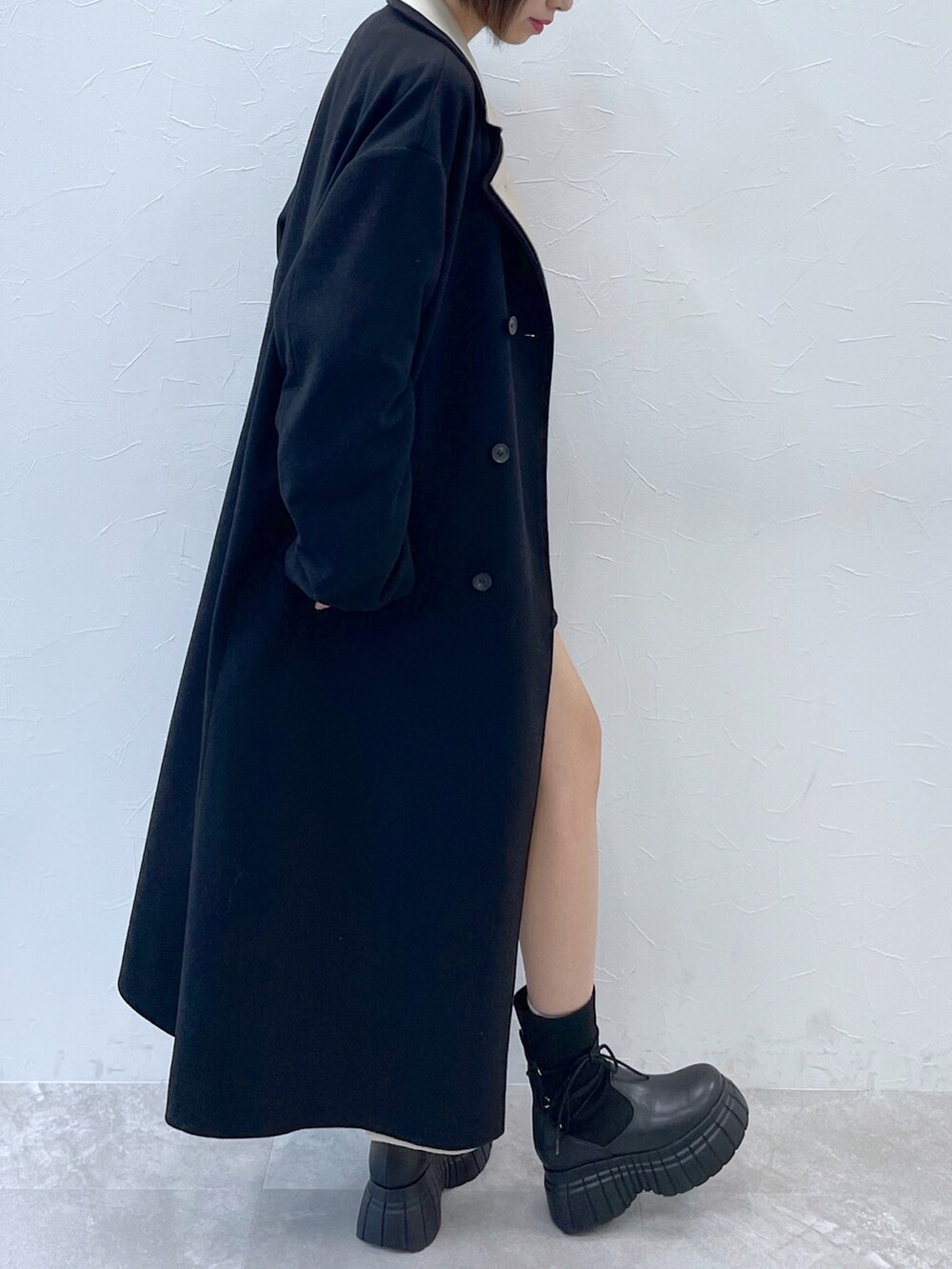 ブラック系のその他アウター、ブラック系のニット/セーター、ブラック系のブーツを着用したレディースの秋コーディネートの2枚目の写真