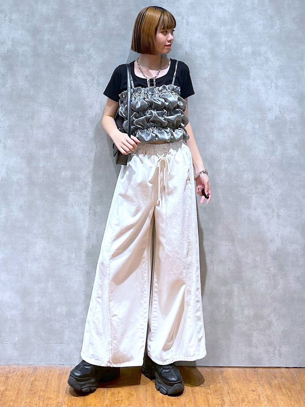 ブラック系のスニーカー、ホワイト系のデニムパンツ、ブラック系のハンドバッグを着用したレディースの夏コーディネートの5枚目の写真