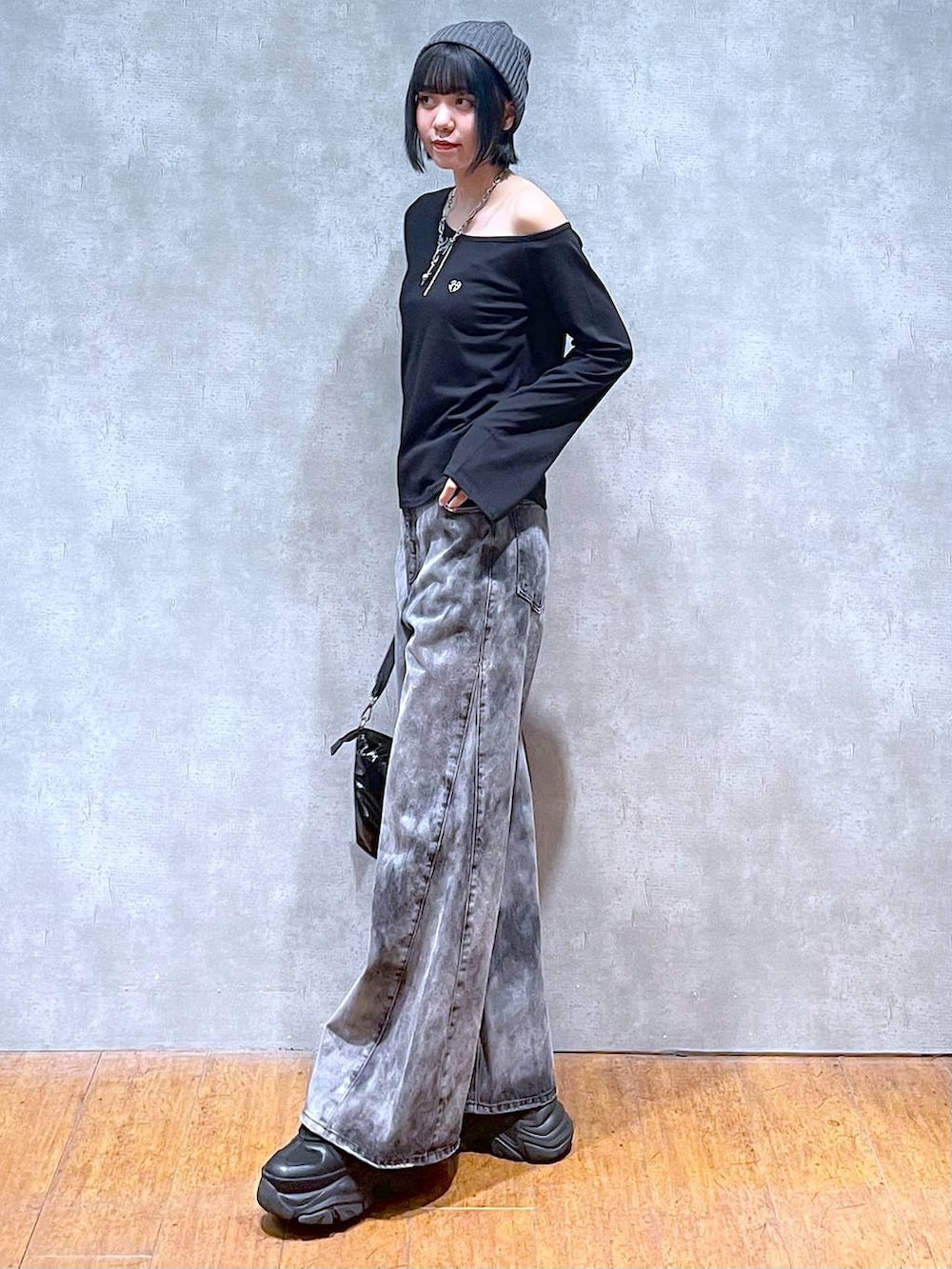 ブラック系のスニーカー、ブラック系のショルダーバッグ、ブラック系のデニムパンツを着用したレディースの夏コーディネートの5枚目の写真