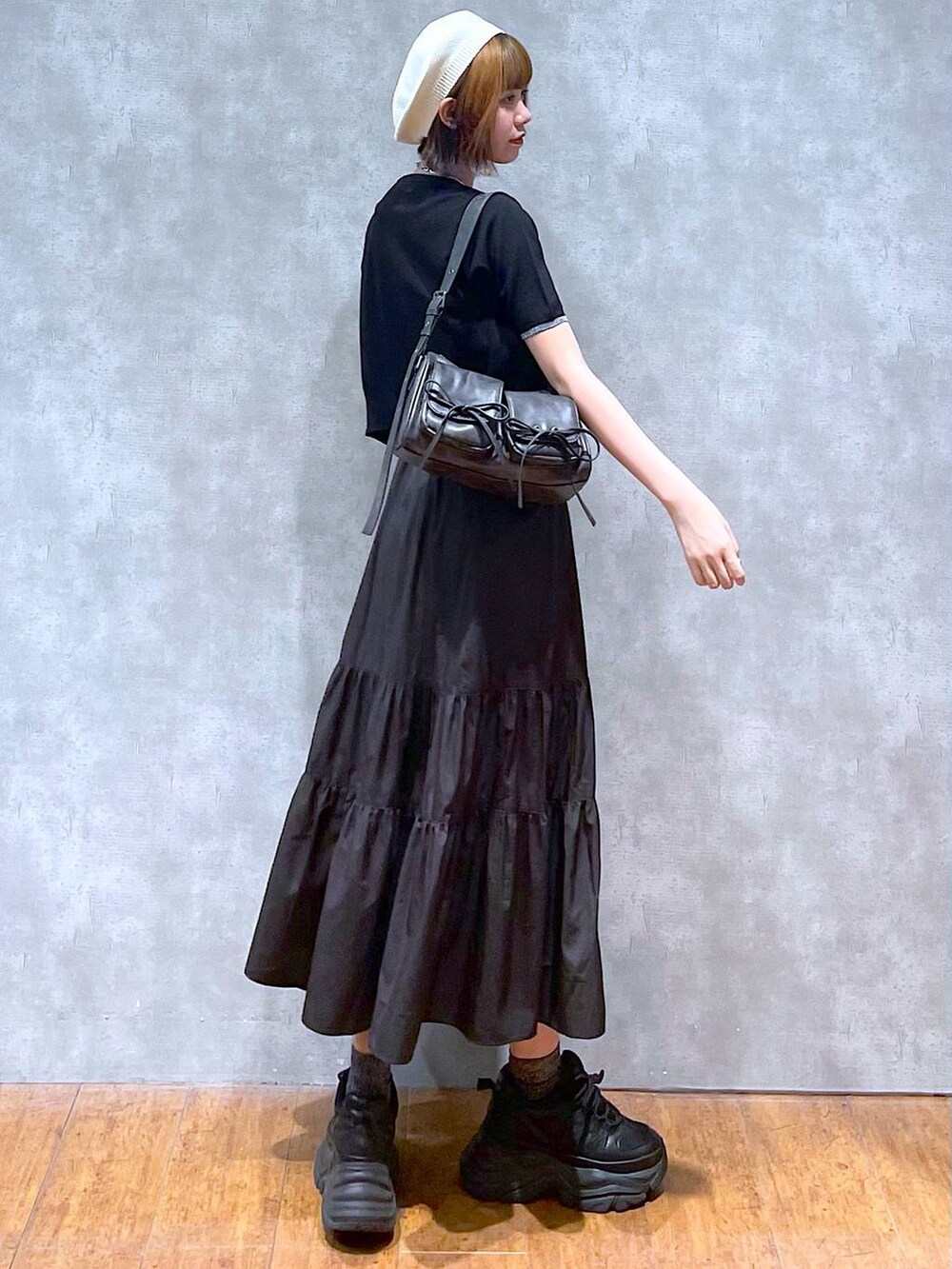 ブラック系のスニーカー、ブラック系のワンピース、ブラック系のショルダーバッグを着用したレディースの夏コーディネートの4枚目の写真