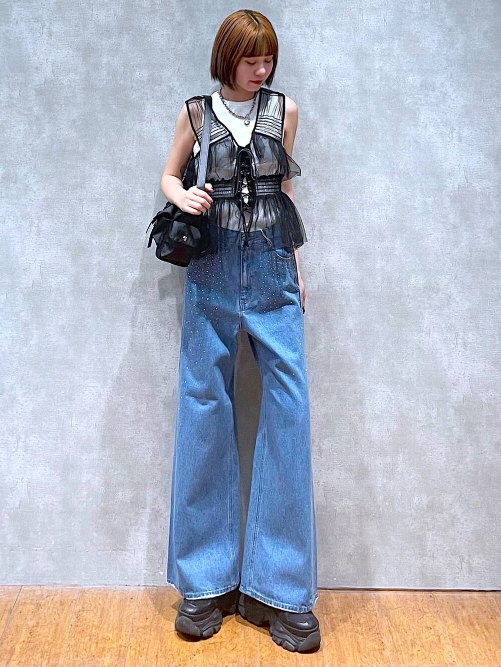 ブラック系のショルダーバッグ、ブラック系のスニーカー、ブラック系のベストを着用したレディースの夏コーディネートの2枚目の写真