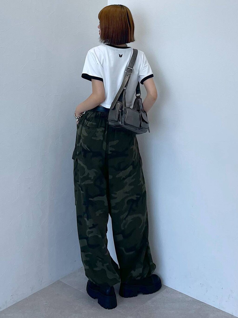 ブラック系のブーツ、グリーン系のカーゴパンツ、シルバー系のブレスレットを着用したレディースの夏コーディネートの3枚目の写真