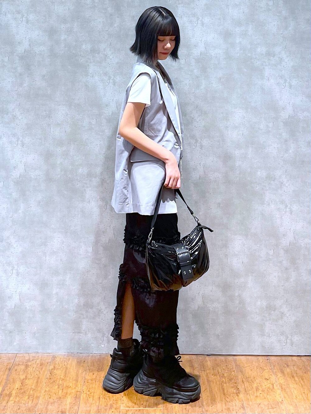 ブラック系のスニーカー、ホワイト系のTシャツ/カットソー、ブラック系のショルダーバッグを着用したレディースの夏コーディネートの4枚目の写真