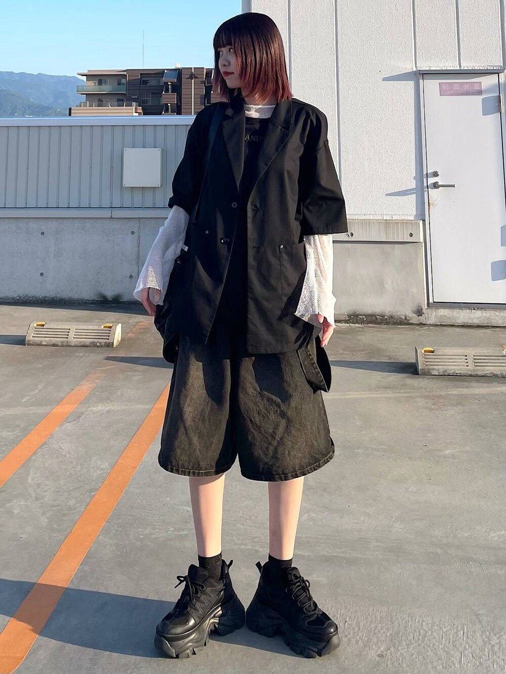 ブラック系のショルダーバッグ、ブラック系のスニーカー、ホワイト系のTシャツ/カットソーを着用したレディースの春コーディネートの3枚目の写真