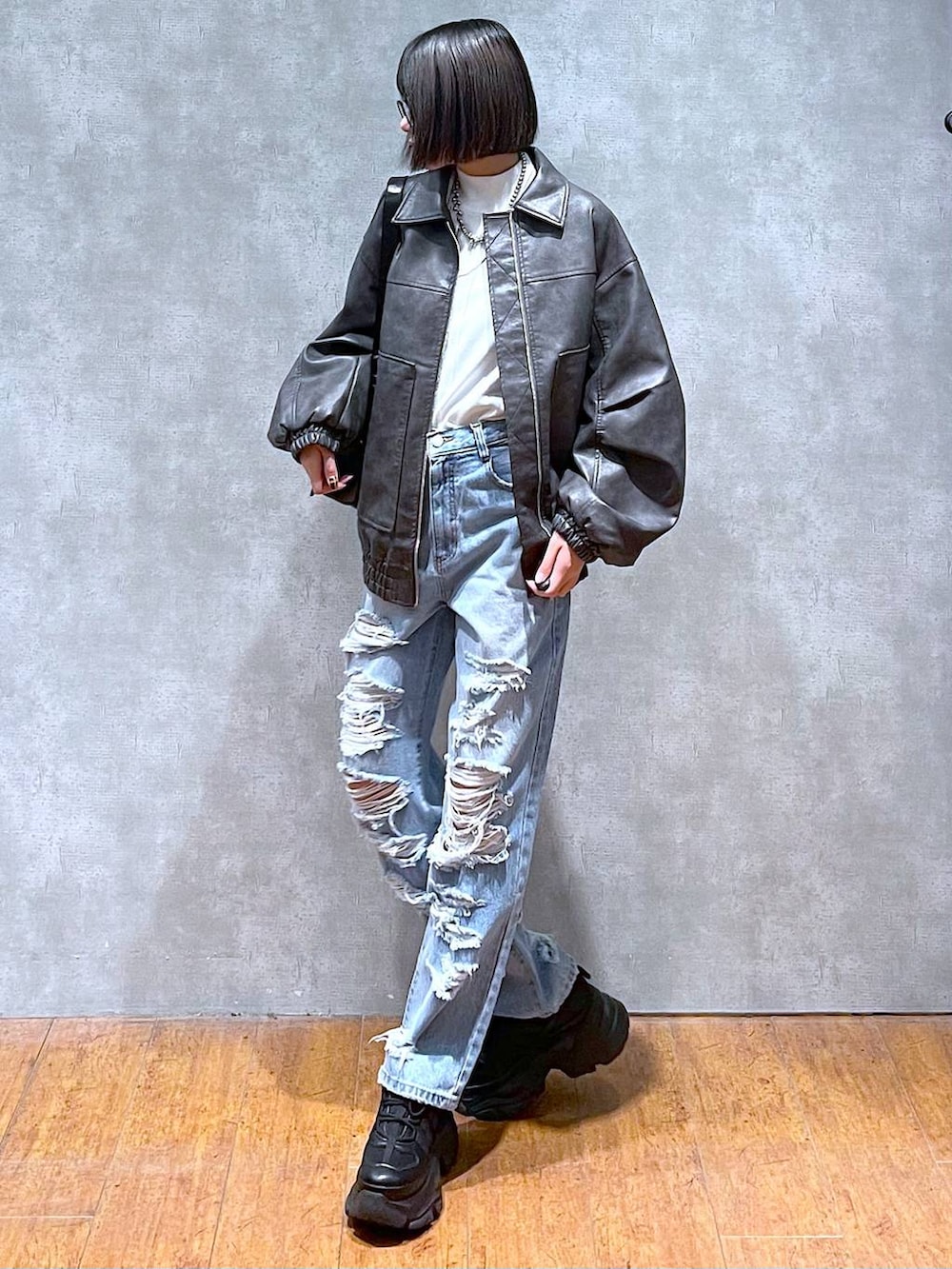 ブラック系のスニーカー、ブルー系のデニムパンツ、グレー系のブルゾンを着用したレディースの秋コーディネートの2枚目の写真