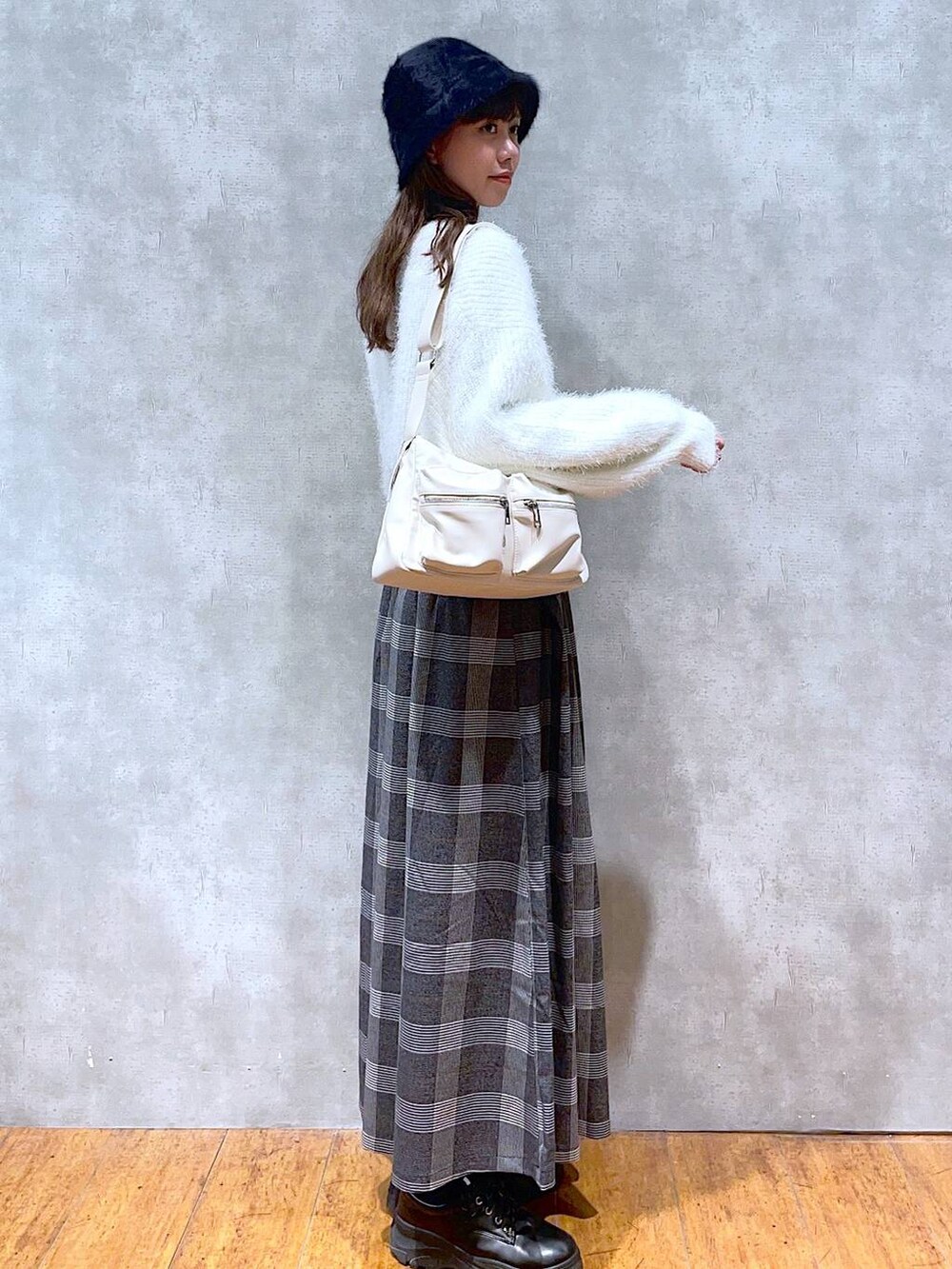 ホワイト系のショルダーバッグ、ホワイト系のカーディガン/ボレロ、ブラック系のスカートを着用したレディースの秋コーディネートの2枚目の写真