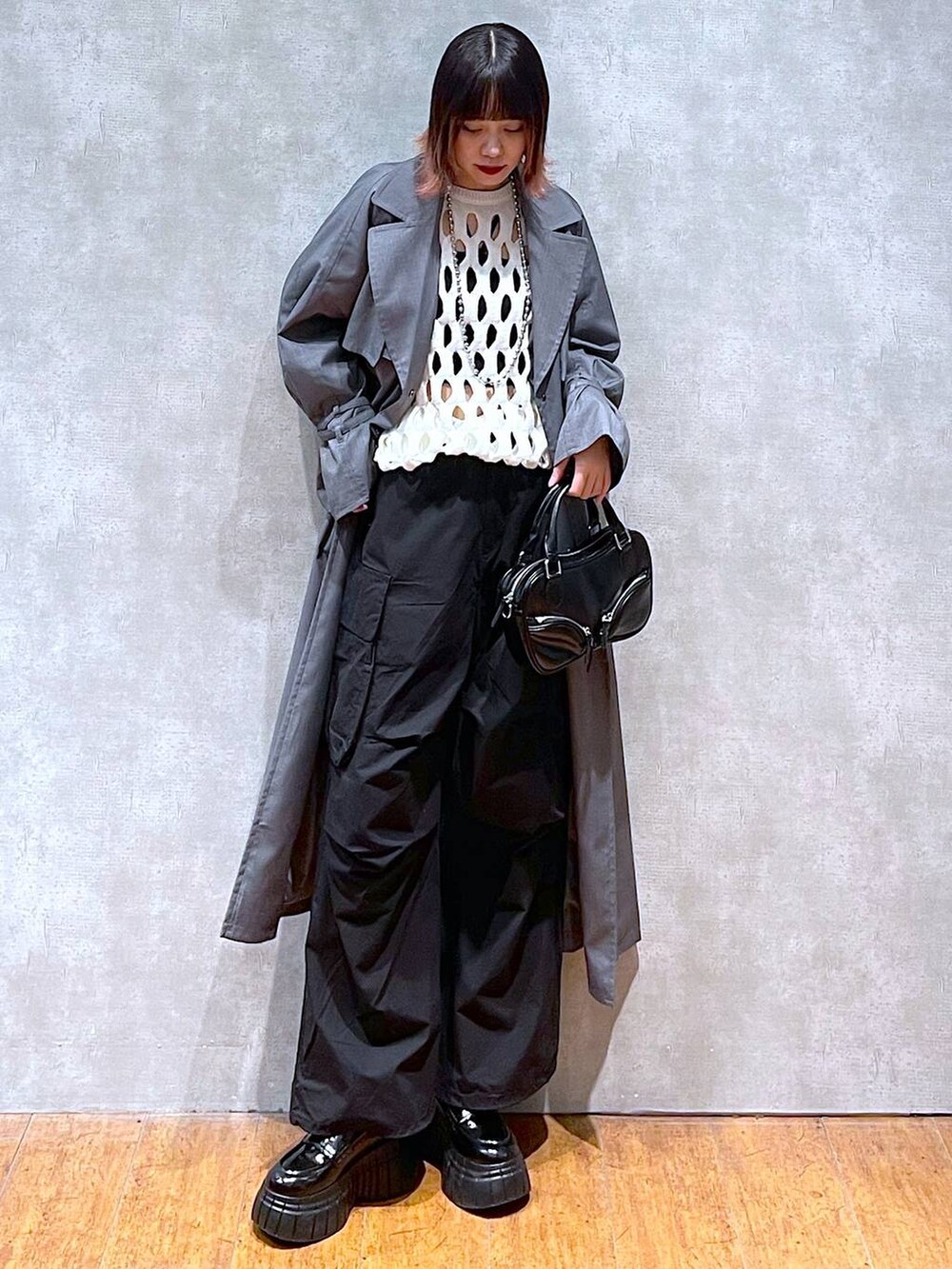 ホワイト系のニット/セーター、ブラック系のカーゴパンツ、ブラック系のキャミソールを着用したレディースの春コーディネートの3枚目の写真