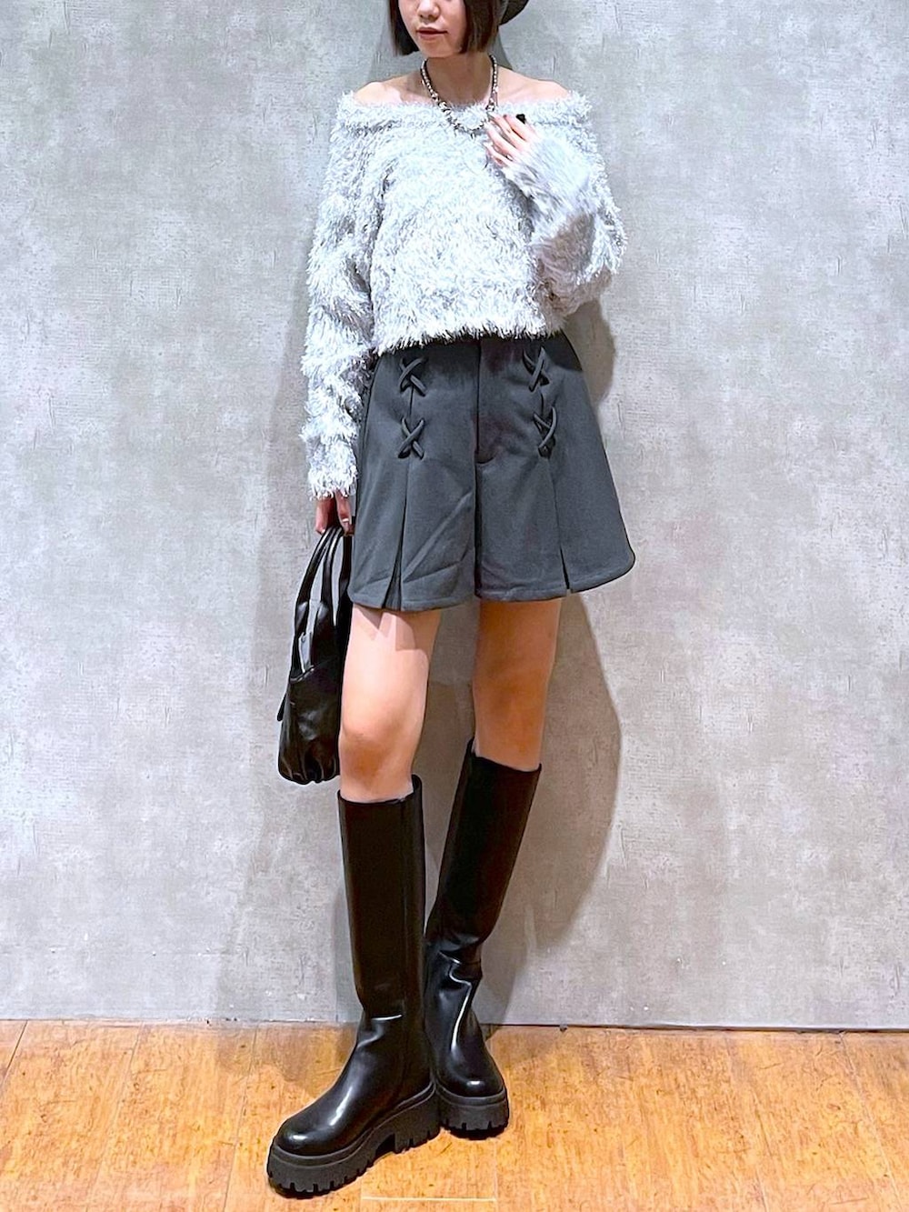 グレー系のその他パンツ、ブラック系のハンドバッグ、ブラック系のブーツを着用したレディースの秋コーディネートの2枚目の写真