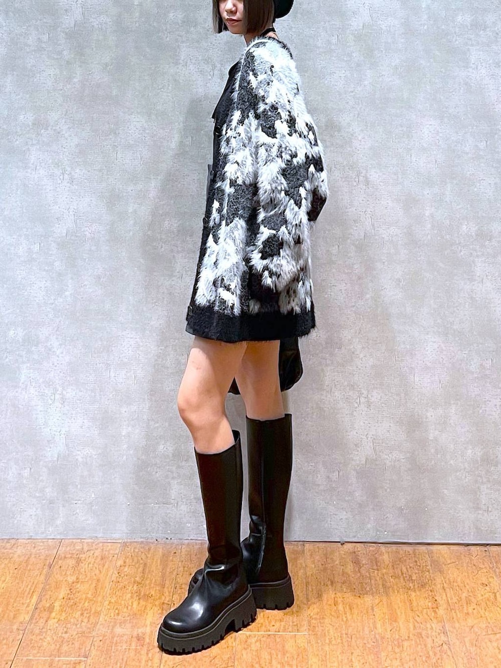 ブラック系のニット/セーター、グレー系のその他パンツ、ブラック系のブーツを着用したレディースの秋コーディネートの4枚目の写真