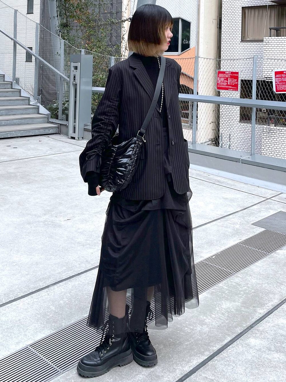 その他のテーラードジャケット、ブラック系のショルダーバッグ、ブラック系のブーツを着用したレディースの冬コーディネートの2枚目の写真