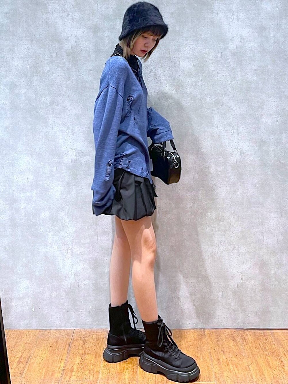 ブラック系のTシャツ/カットソー、ブラック系のスカート、ブラック系のボストンバッグを着用したレディースの冬コーディネートの6枚目の写真