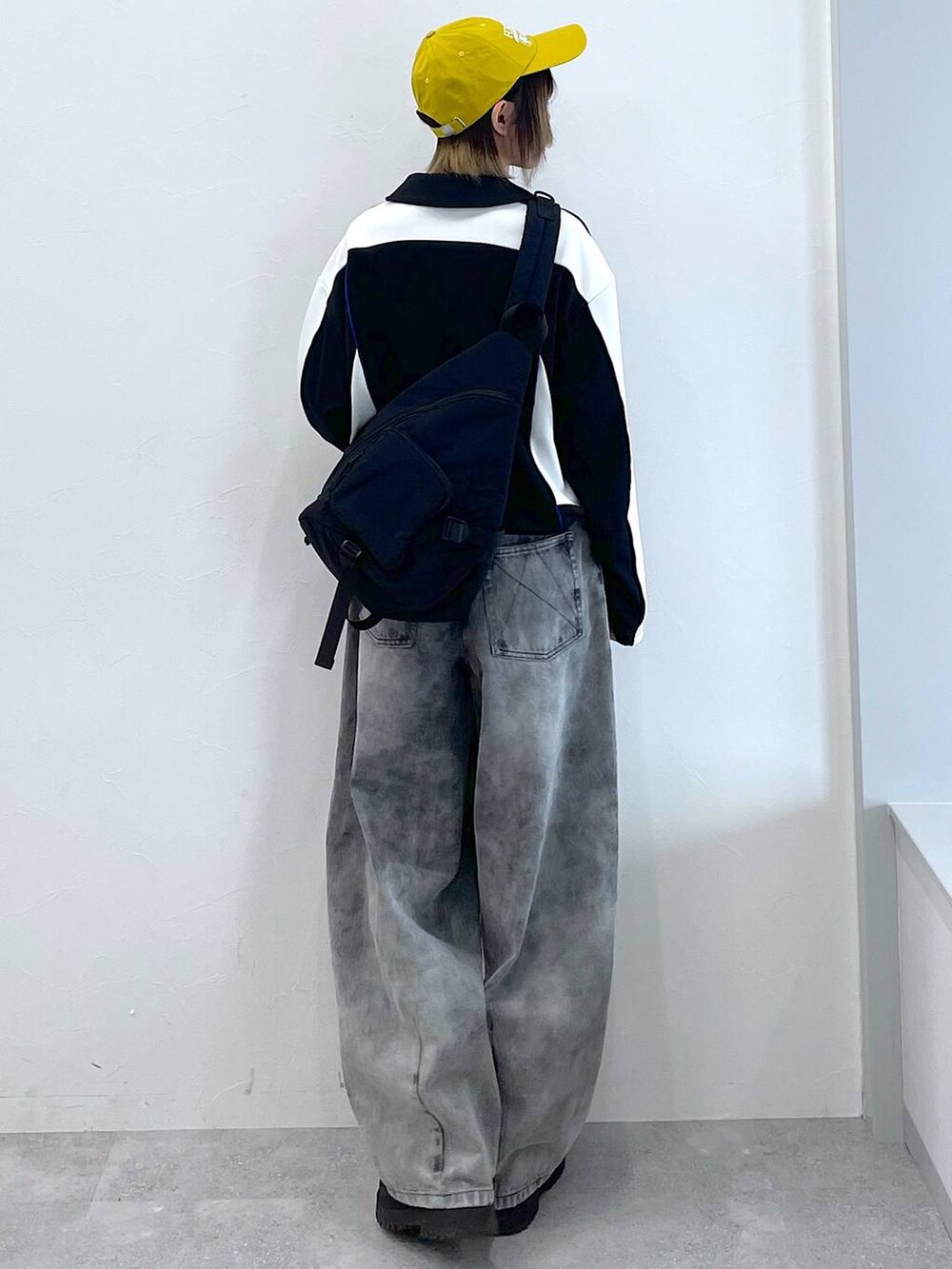 ブラック系のデニムパンツ、ブラック系のボディバッグ/ウエストポーチ、ブラック系のブーツを着用したレディースの冬コーディネートの6枚目の写真