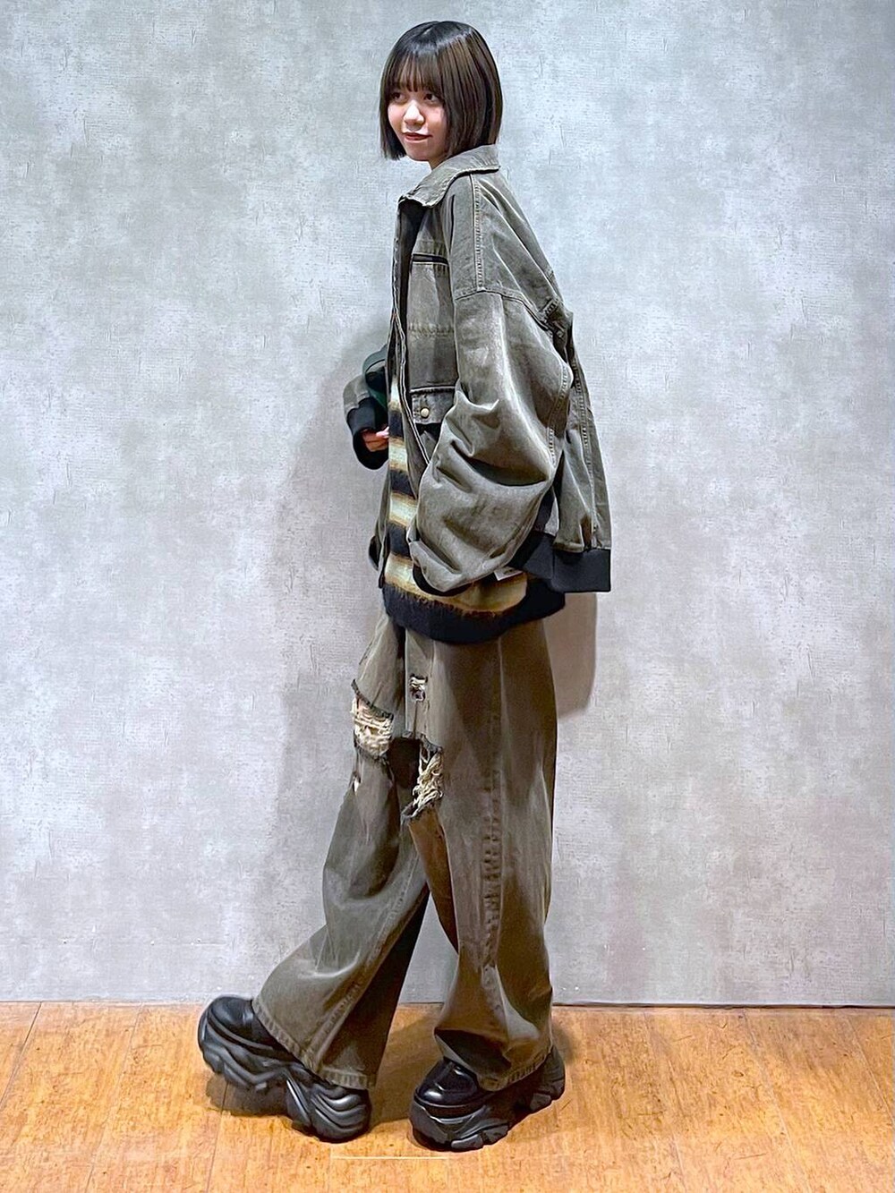 ブラック系のスニーカー、ブラック系のデニムパンツ、ブラック系のブルゾンを着用したレディースの秋コーディネートの7枚目の写真