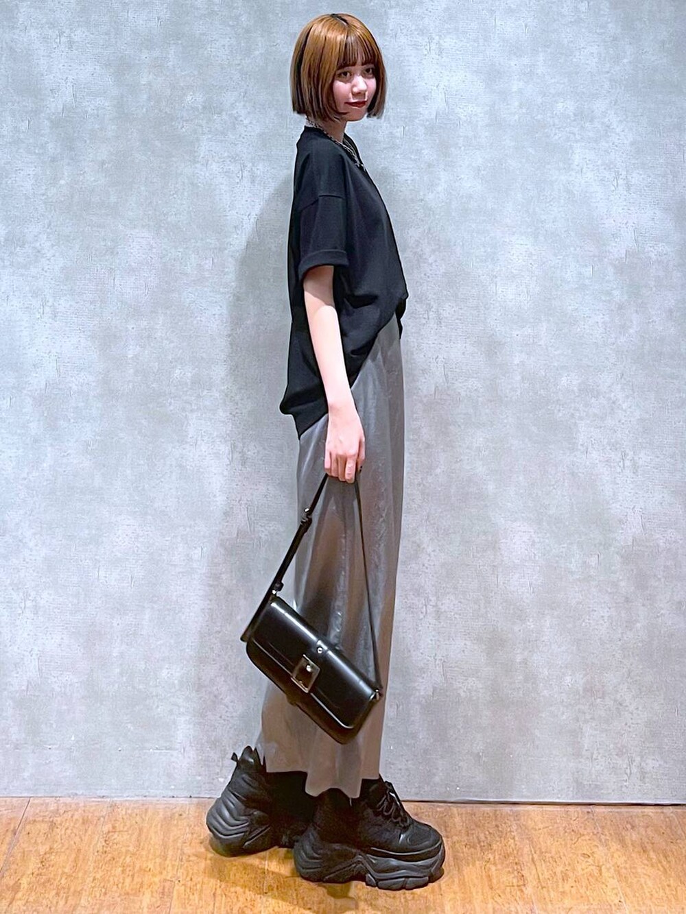 ブラック系のスニーカー、ブラック系のハンドバッグ、ブラック系のTシャツ/カットソーを着用したレディースの夏コーディネートの4枚目の写真