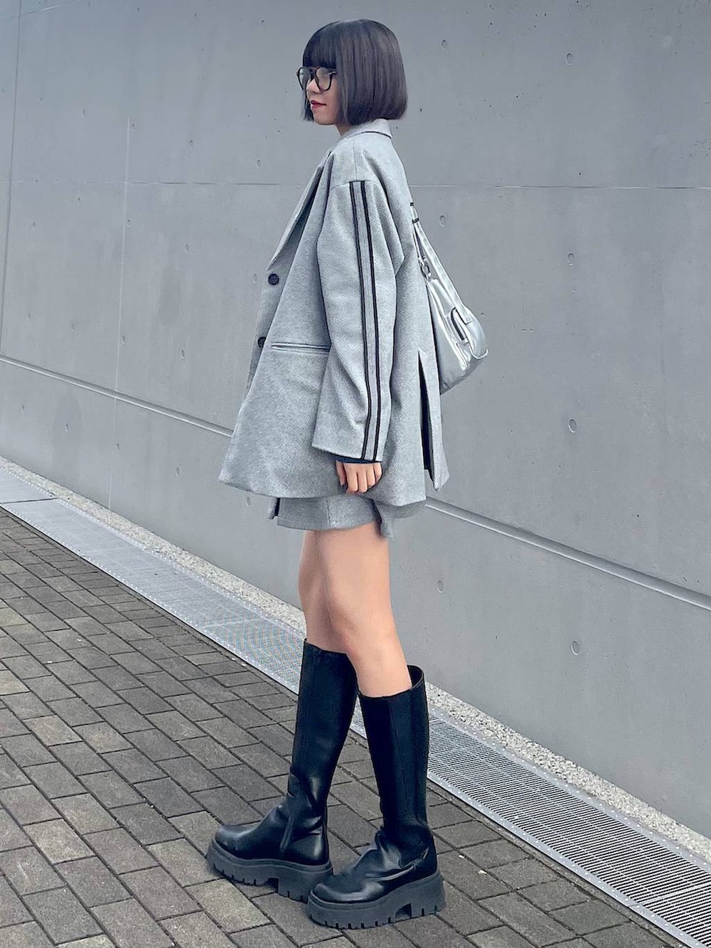 シルバー系のショルダーバッグ、ブラック系のその他パンツ、ブラック系のテーラードジャケットを着用したレディースの秋コーディネートの2枚目の写真