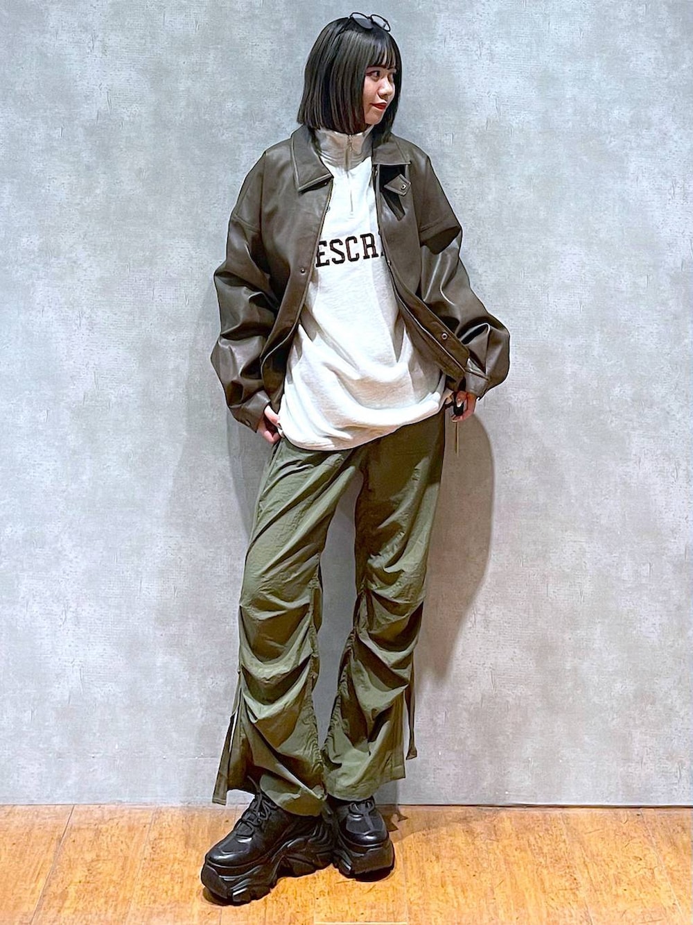 ブラック系のスニーカー、グリーン系のカーゴパンツ、ブラウン系のブルゾンを着用したレディースの秋コーディネートの3枚目の写真