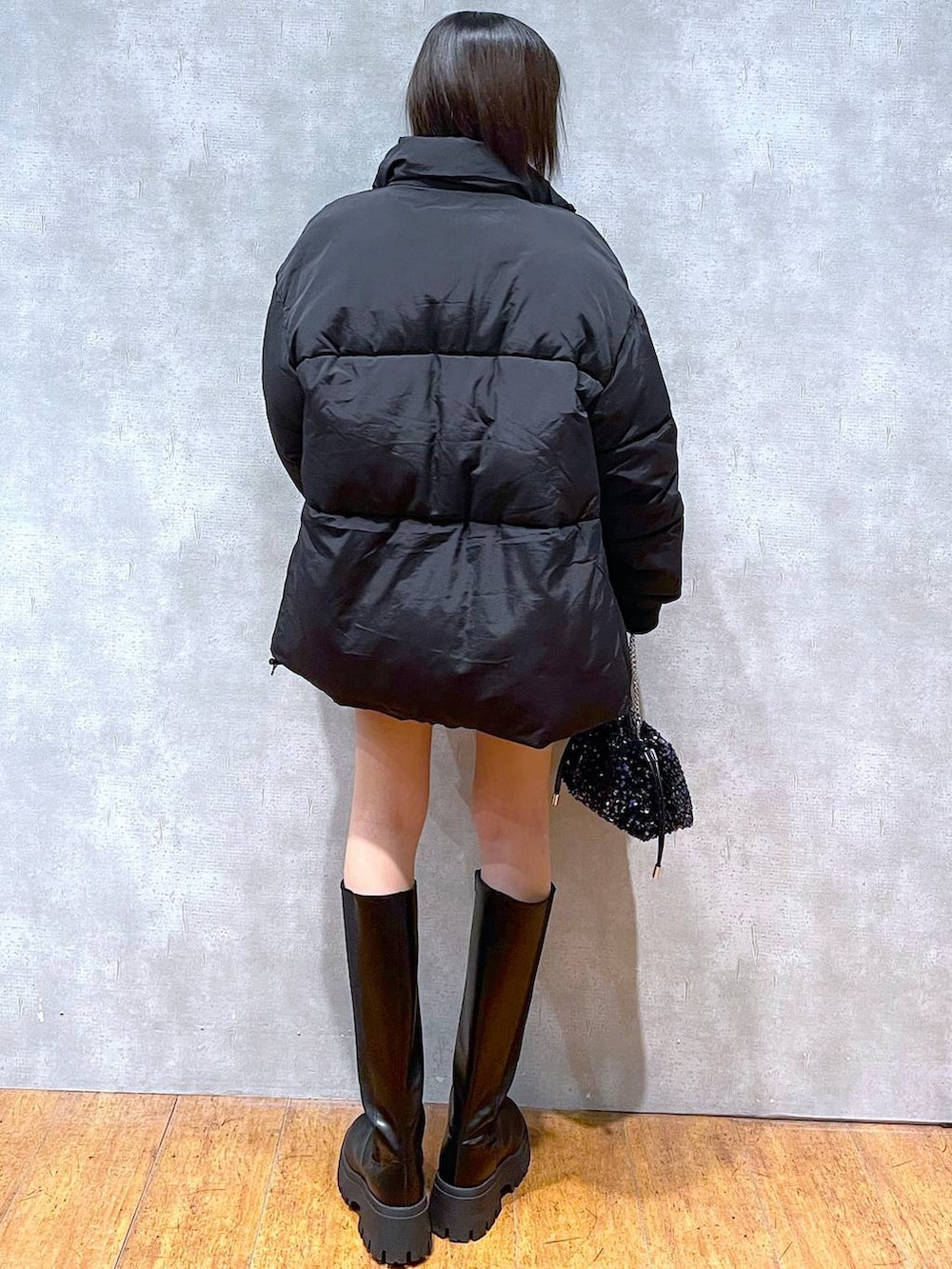 ブラック系のスカート、ブラック系のブーツ、ブラック系のダウンジャケット/コートを着用したレディースの冬コーディネートの3枚目の写真