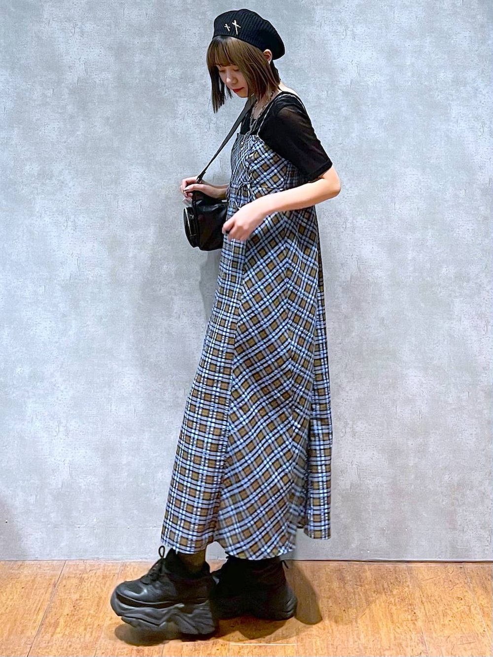 ブラック系のスニーカー、ブラック系のショルダーバッグ、ブルー系のワンピースを着用したレディースの秋コーディネートの5枚目の写真