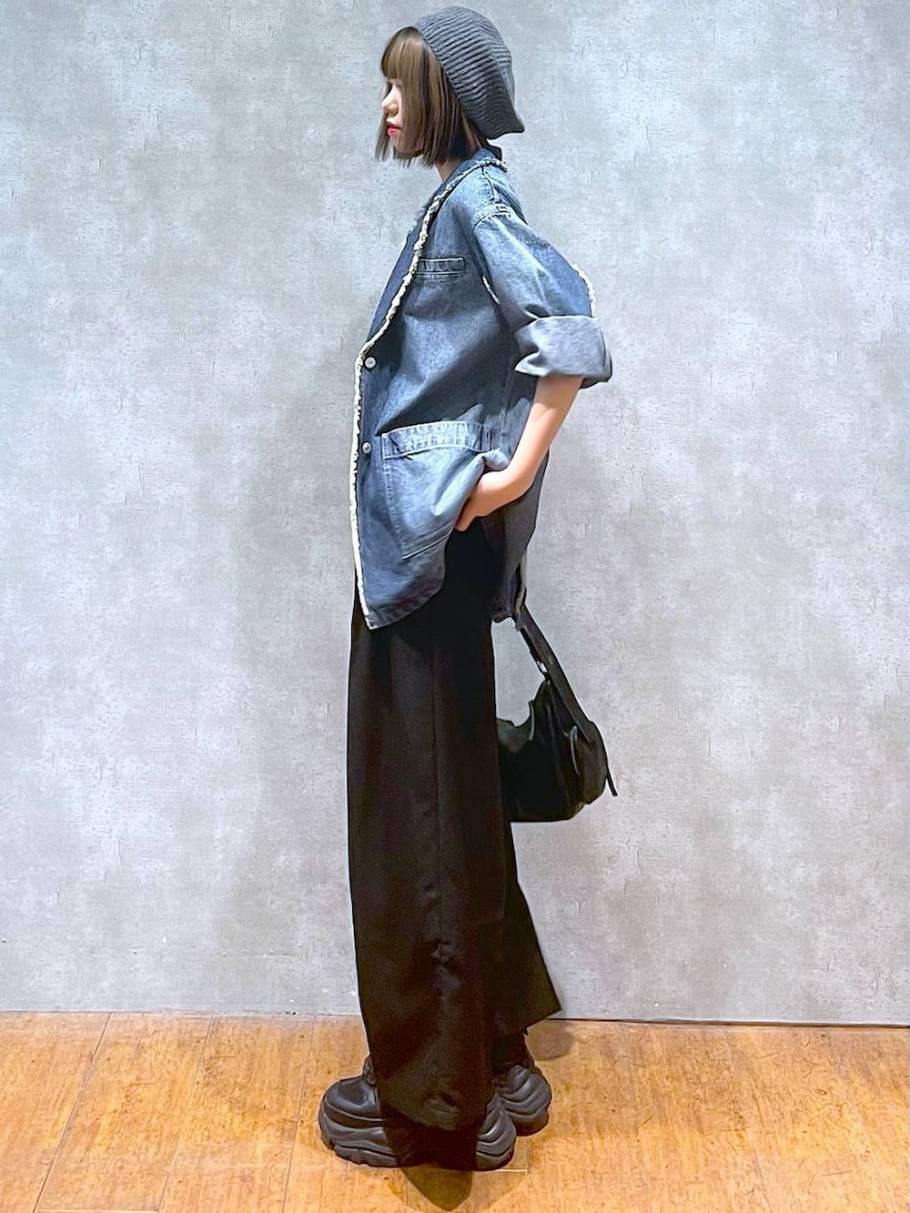 ブラック系のスニーカー、ブルー系のテーラードジャケット、ブラック系のキャミソールを着用したレディースの秋コーディネートの4枚目の写真