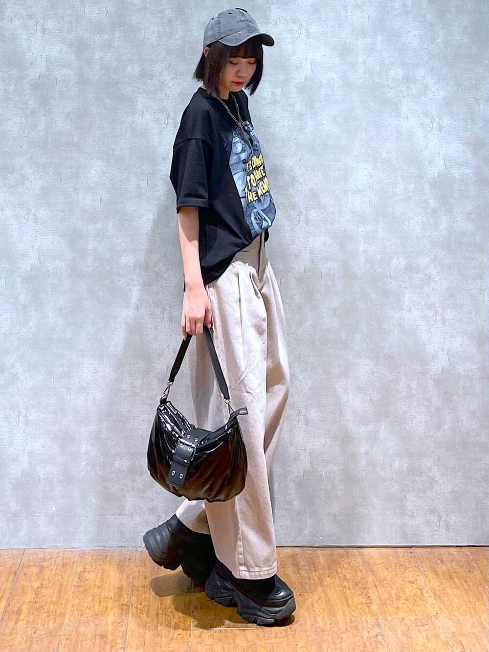 ブラック系のスニーカー、ブラック系のショルダーバッグ、ベージュ系のデニムパンツを着用したレディースの夏コーディネートの8枚目の写真