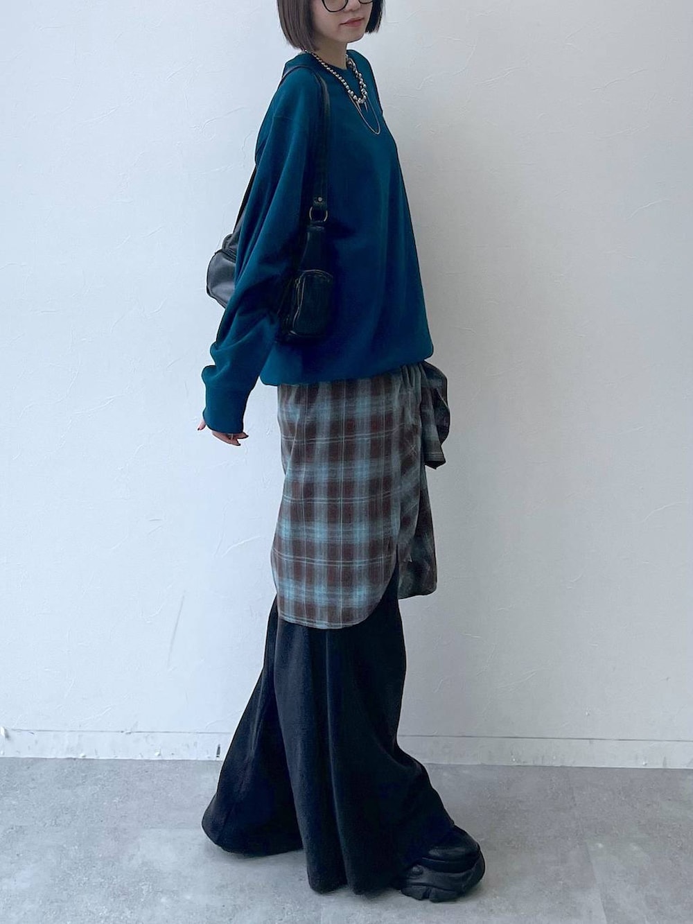 ブラック系のスニーカー、ブラック系のショルダーバッグ、グリーン系のスウェットを着用したレディースの秋コーディネートの7枚目の写真