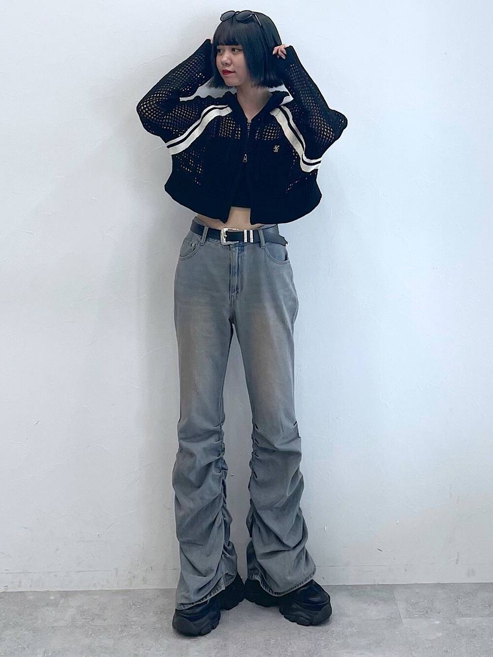 ブラック系のスニーカー、ブラック系のキャミソール、ブルー系のデニムパンツを着用したレディースの夏コーディネートの5枚目の写真