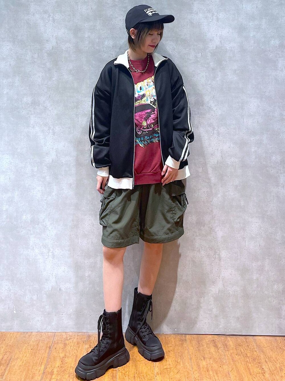 ブラック系のその他アウター、グリーン系のカーゴパンツ、ブラック系のブーツを着用したレディースの冬コーディネートの3枚目の写真