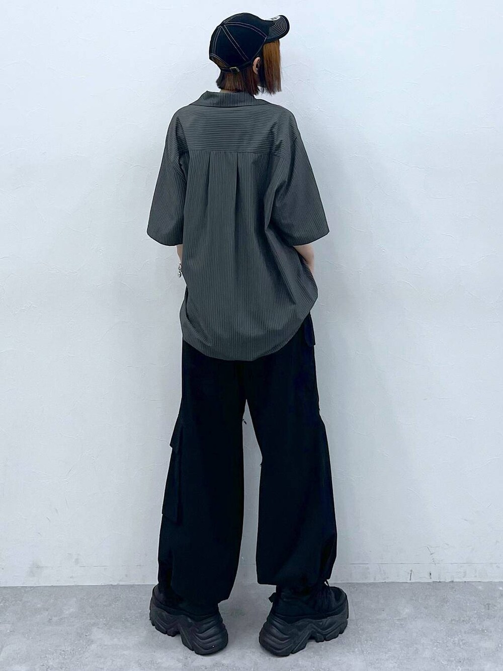 ブラック系のスニーカー、ブラック系のキャミソール、ブラック系のカーゴパンツを着用したレディースの夏コーディネートの5枚目の写真