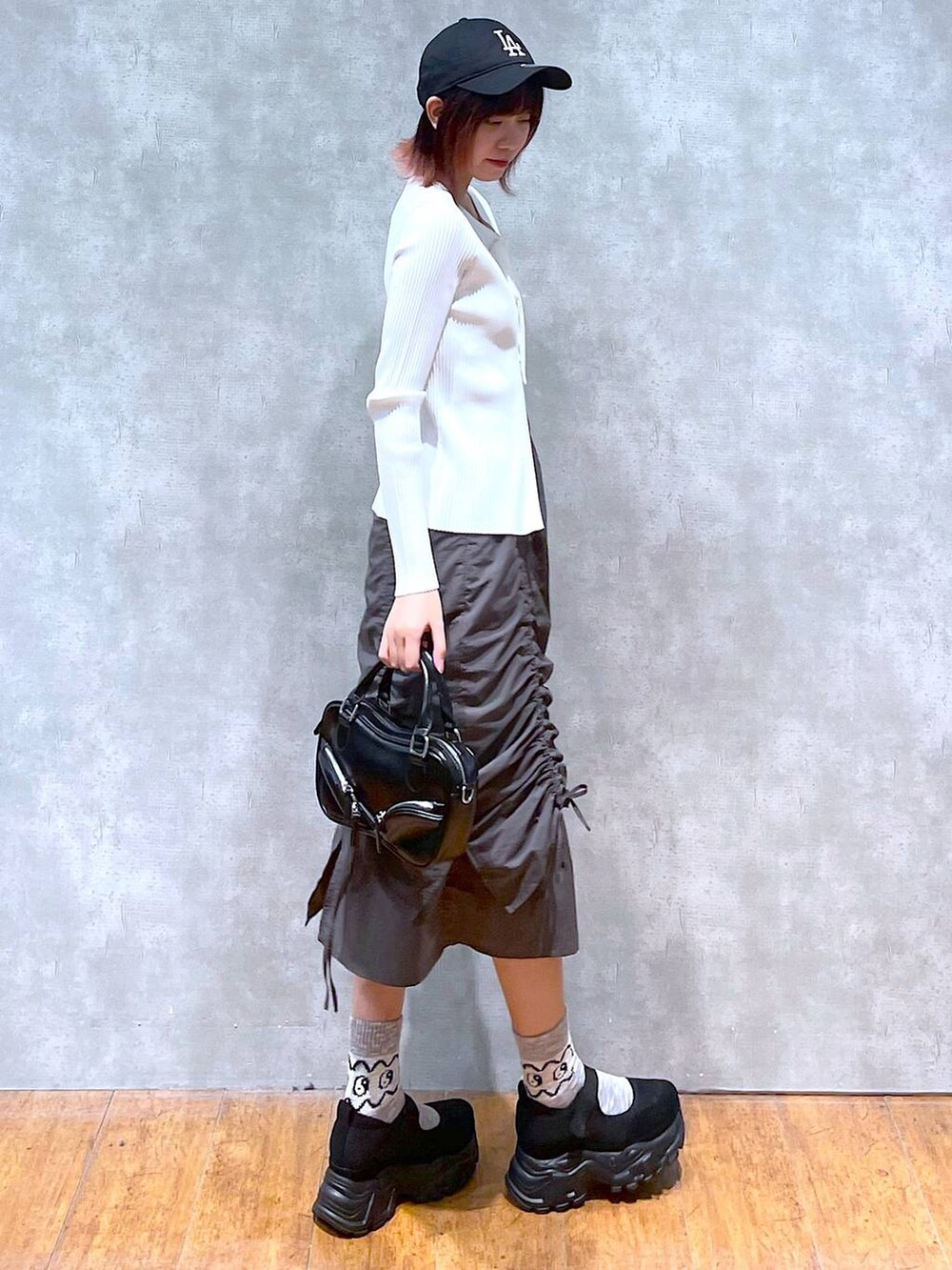 ホワイト系のニット/セーター、ホワイト系のキャミソール、ブラック系のボストンバッグを着用したレディースの春コーディネートの4枚目の写真
