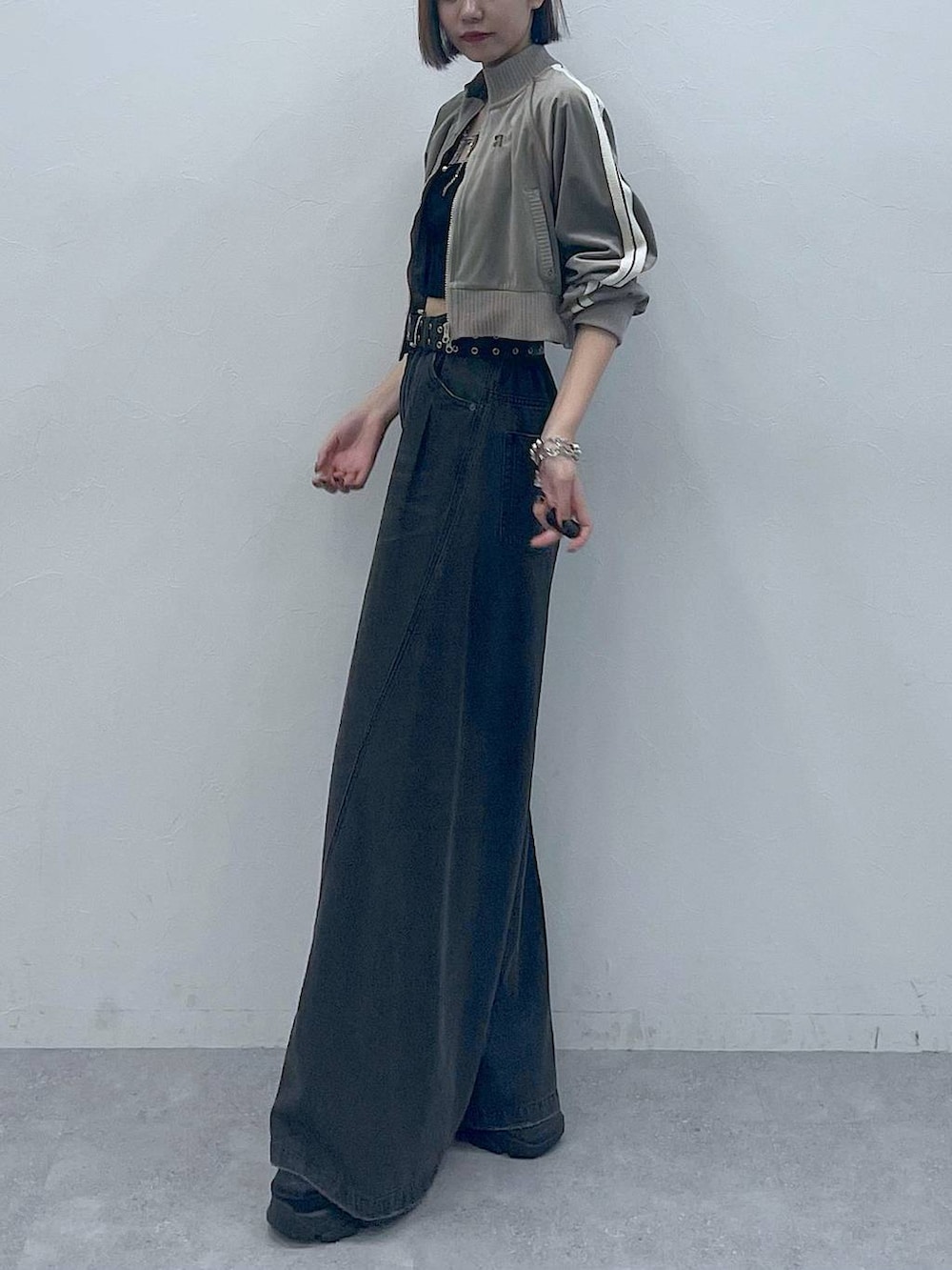 ブラック系のスニーカー、ブラック系のキャミソール、ブラック系のデニムパンツを着用したレディースの秋コーディネートの5枚目の写真