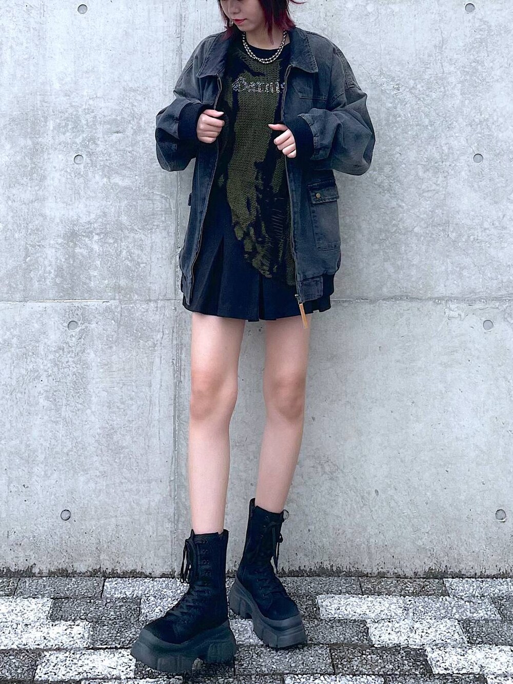 ブラック系のデニムジャケット、グリーン系のニット/セーター、ブラック系のその他パンツを着用したレディースの春コーディネートの5枚目の写真