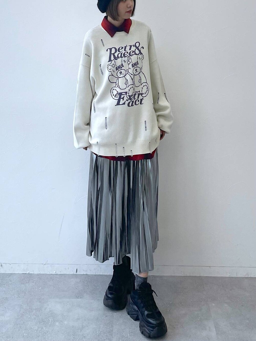 ブラック系のスニーカー、グレー系のスカート、ホワイト系のニット/セーターを着用したレディースの秋コーディネートの8枚目の写真