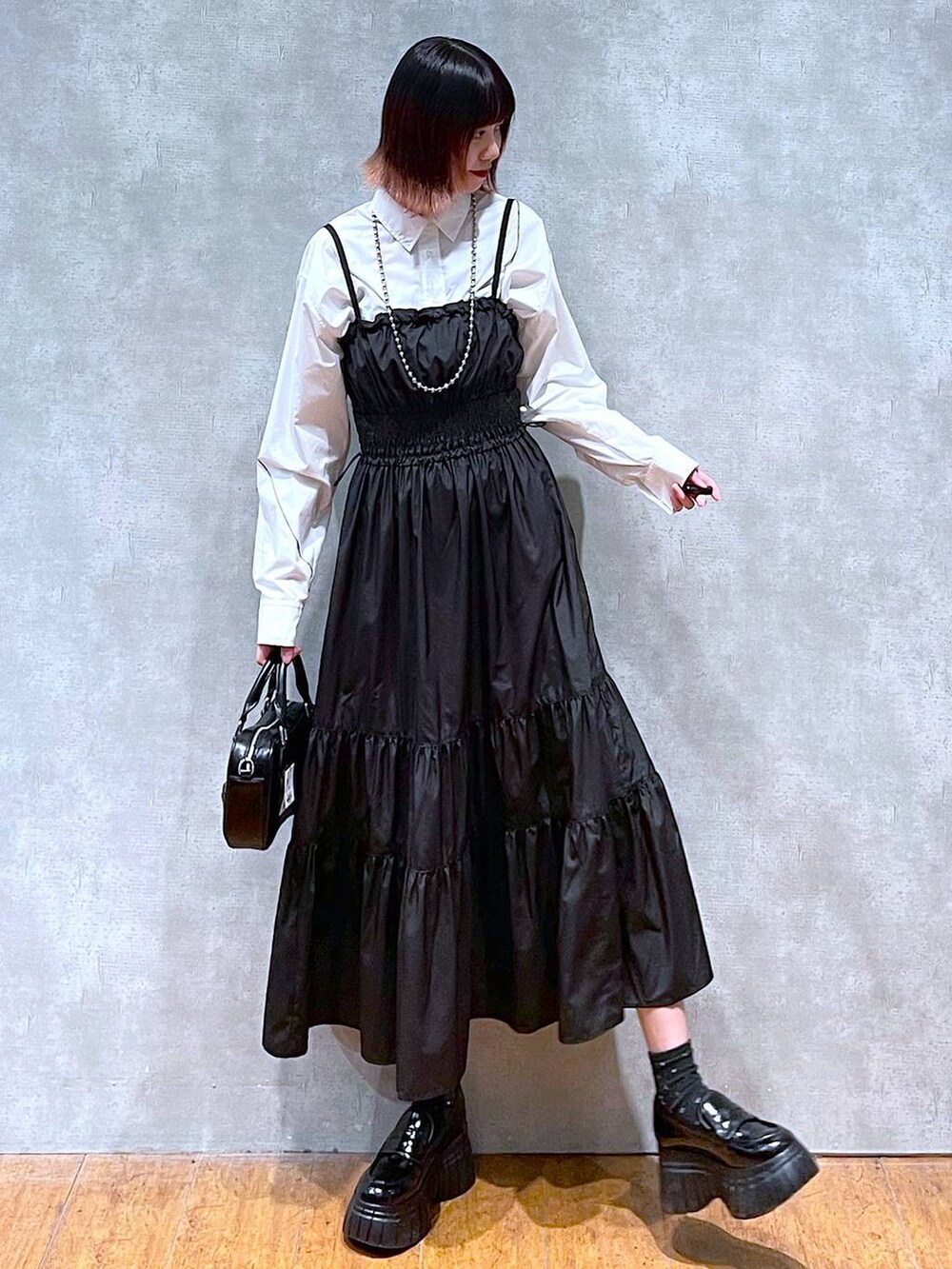 ホワイト系のシャツ/ブラウス、ブラック系のローファー、ブラック系のボストンバッグを着用したレディースの春コーディネートの6枚目の写真