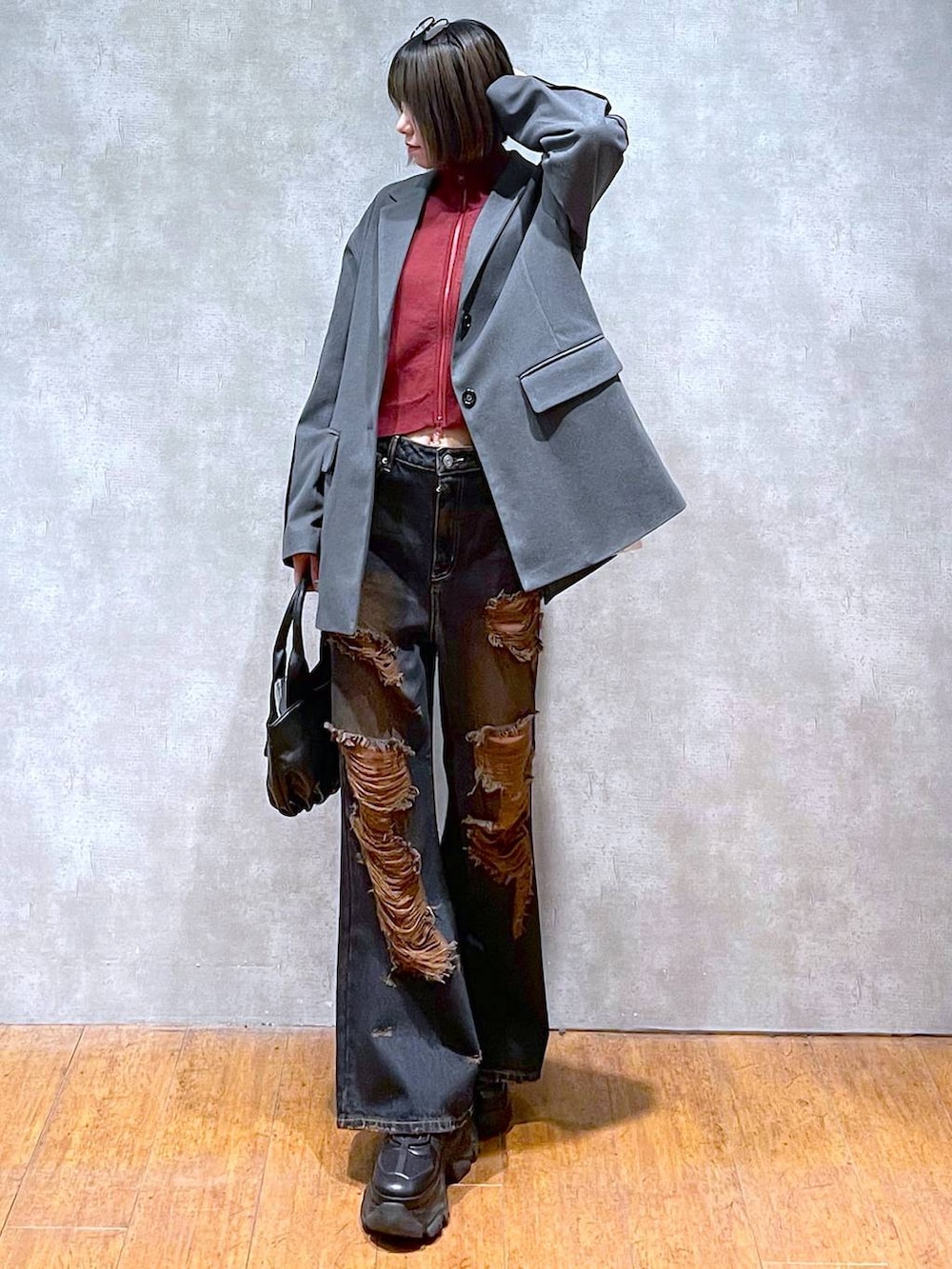 ブラック系のスニーカー、レッド系のニット/セーター、ブラック系のハンドバッグを着用したレディースの秋コーディネートの3枚目の写真