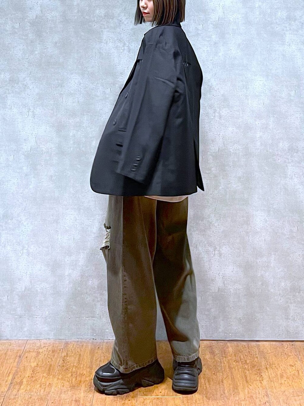 ブラック系のスニーカー、ベージュ系のTシャツ/カットソー、ブラック系のデニムパンツを着用したレディースの秋コーディネートの6枚目の写真